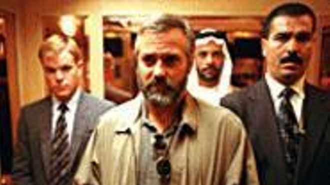 George Clooney (center) plays a failed CIA assassin surrounded by corruption.