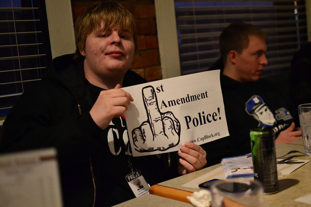 Jacob Frost, the 22-year-old head of the Bellevue-based Ohio Cop Block chapter, holds up the sign created by "Chuck," a new Cop Block associate.
