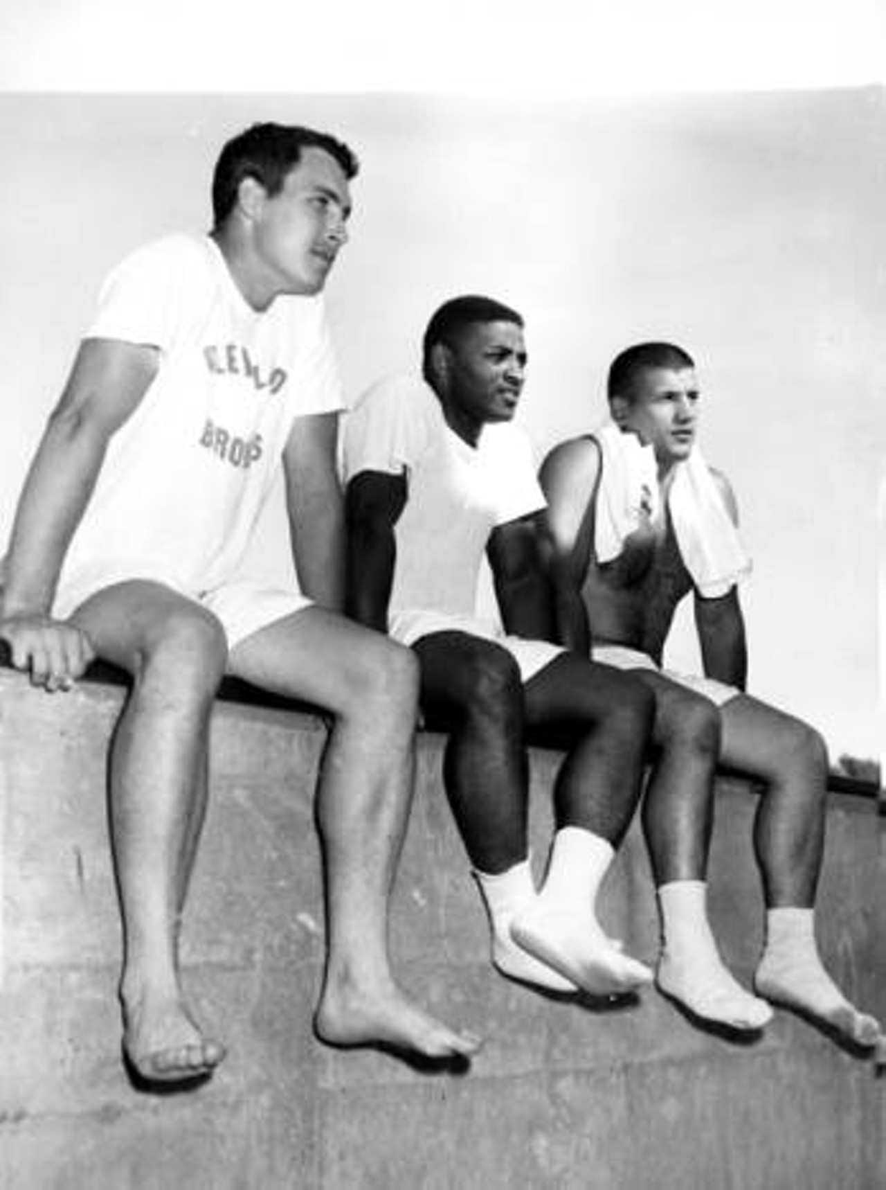 Relaxing at 1964 training camp (left to right) are quarterback Frank Ryan, running back Charlie Scales, and linebacker Vince Costello.