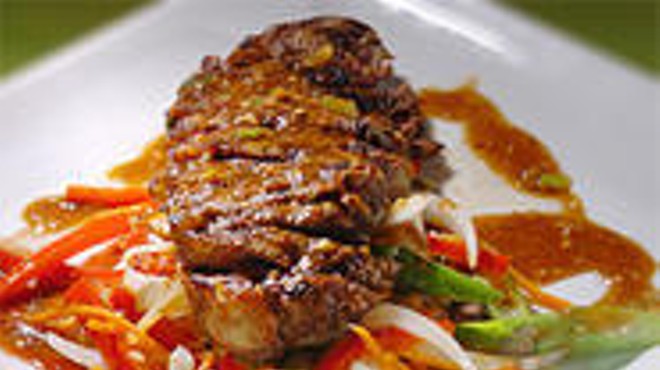 The Thai-inspired Satay Strip Steak, on a bed of onions and asparagus.