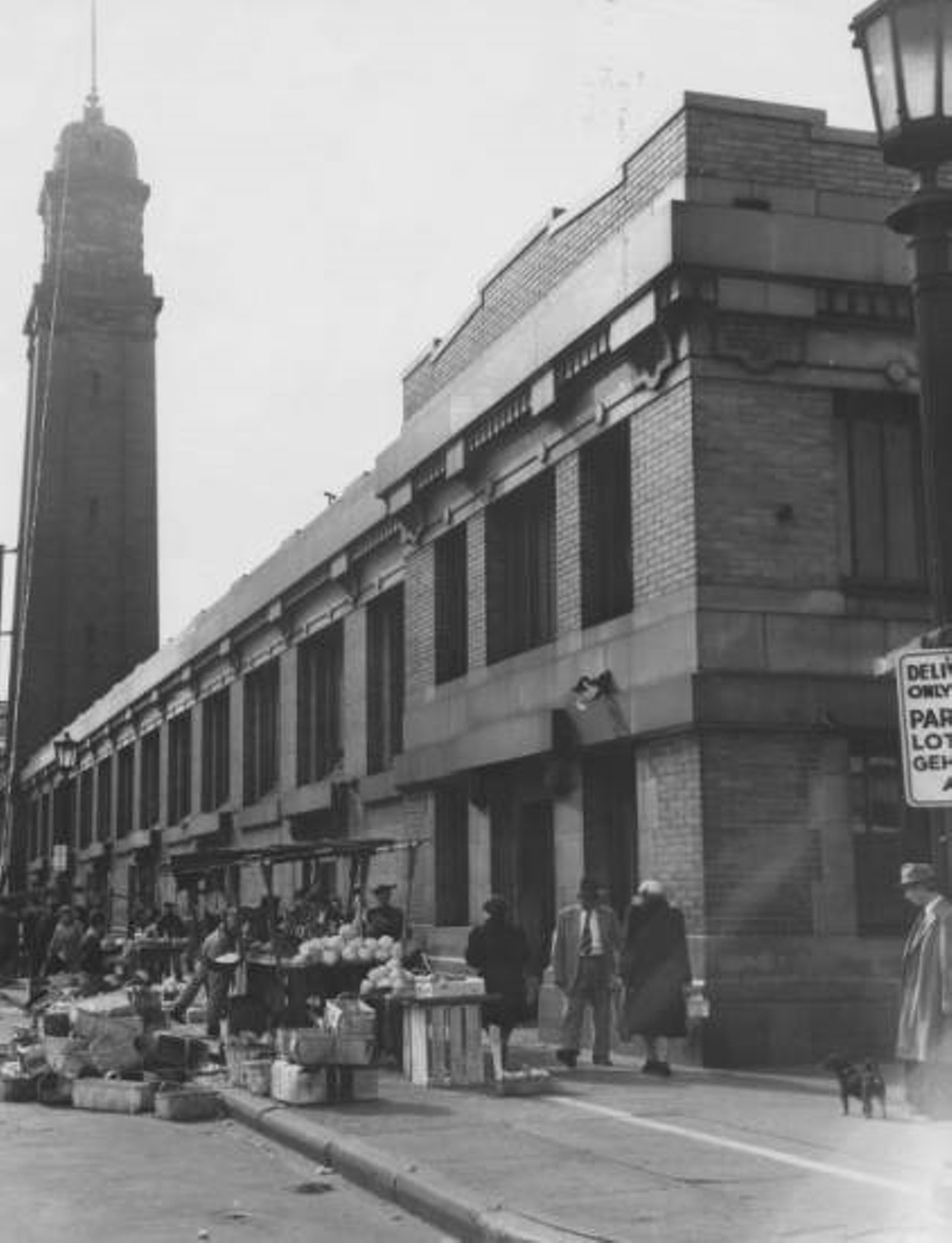 View of south side of market building and produce vendors located along the Lorain Avenue sidewalk. c. 1946