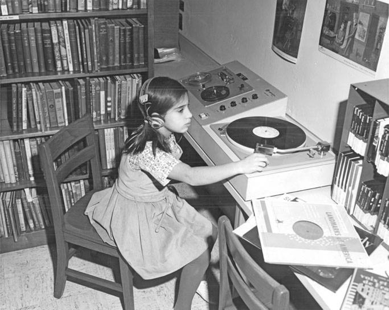 Barbara Gross, a fourth-grader at Malvern Elementary School, listens to a recording on headphones in the school library. 1966