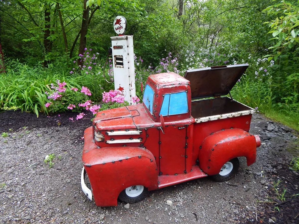 Metal truck artwork surrounded by flowers