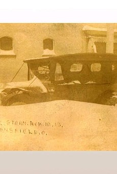 Automobile sitting buried in deep snow after the November 1913 blizzard. Snow reaches the top of the tires.