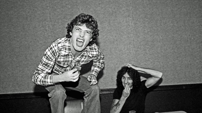Angus Young and Bon Scott at lunch in 1977.