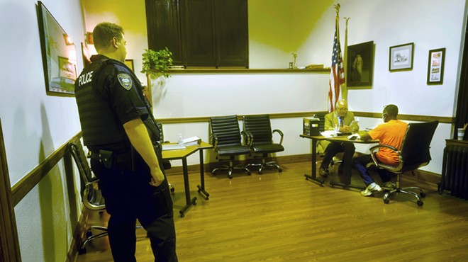 Prosecutor Tom Hanculak, center, talks to a person who received a traffic violation as a Bratenahl police officer watches over the proceedings on Oct. 11, 2022.