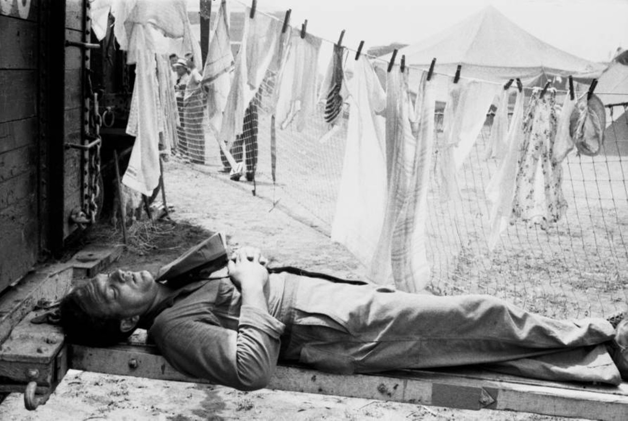 Uniformed Man Sleeping Beside Clothes Line