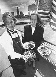Ship of foods: Seafaring server Laura Spada (left) with Nautica Queen Restaurant Manager Roxane Dotson. - Walter  Novak