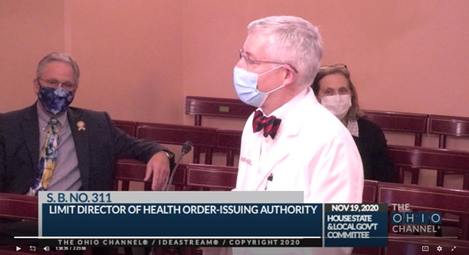 Rep. Stephen Hambley, R-Brunswick, at left, learned a staffer tested positive for COVID-19. Despite having spent 90 minutes with the staffer two days prior, he attended a committee hearing to field testimony from Ohio Department of Health Chief Medical Officer Dr. Bruce Vanderhoff, at right. Source: The Ohio Channel.
