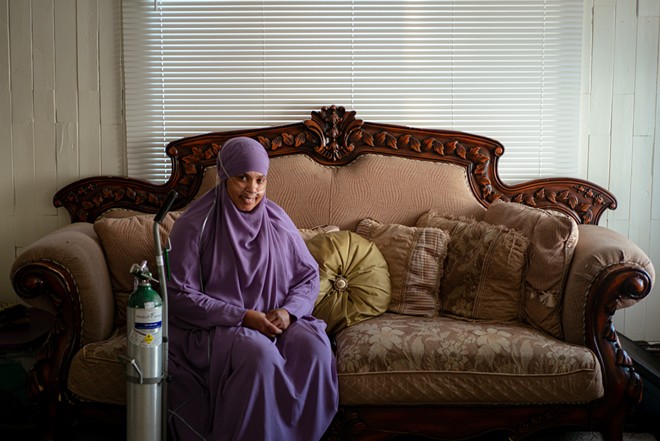 Rashidah Abdulhaqq’s home, where she is pictured here on Jan. 31, was built nearly a century ago, and it’s drafty, she said, driving up her utility bills on top of what it costs her to run the oxygen tank she needs. - Photo by Michael Indriolo