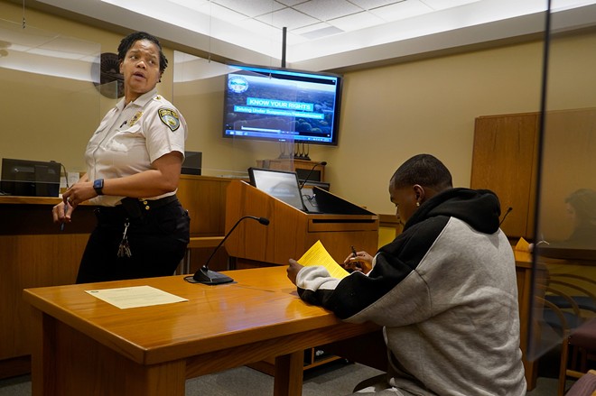 Cassandra Jones, chief administrative bailiff at Cleveland Heights Municipal Court, ushers in people in court for driving under suspension on Jan. 11. The group watched a short video about the court process after meeting with a prosecutor. “We operate on volume,” Jones told reporters. - Gus Chan for The Marshall Project