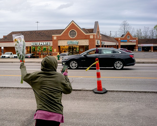 Vincent’s family hands out flowers to passing drivers on Euclid Avenue on April 20, 2021. - Michael Indriolo for The Marshall Project