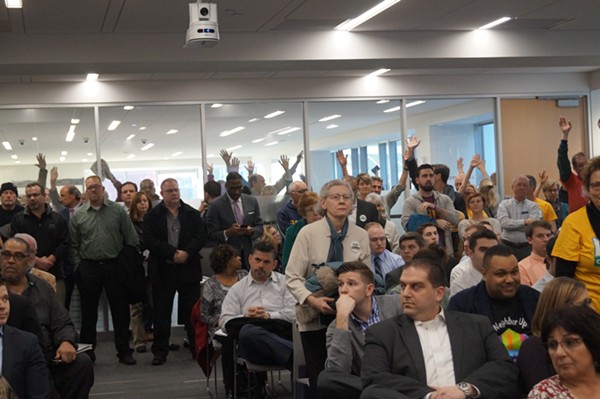 Members of Greater Cleveland Congregations raise their hands at County Council. - Sam Allard / Scene