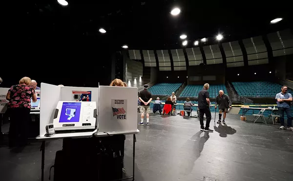 COLUMBUS, OH &mdash; MAY 03: Steve Fuller (center right) walks with a cane to vote on the auditorium stage that serves as the voting location during the Ohio primary election, May 3, 2022, at the Worthington Kilbourne High School, Columbus, Ohio.