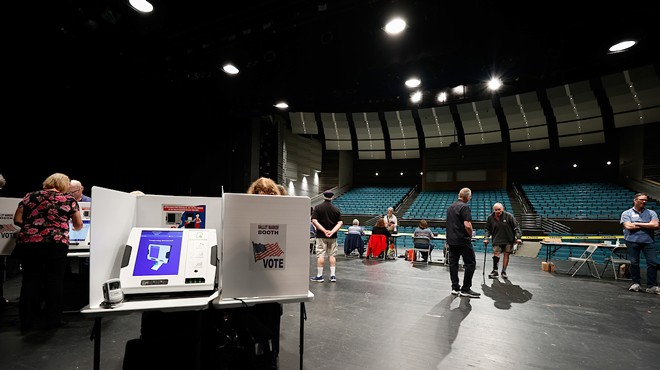 COLUMBUS, OH — MAY 03: Steve Fuller (center right) walks with a cane to vote on the auditorium stage that serves as the voting location during the Ohio primary election, May 3, 2022, at the Worthington Kilbourne High School, Columbus, Ohio.